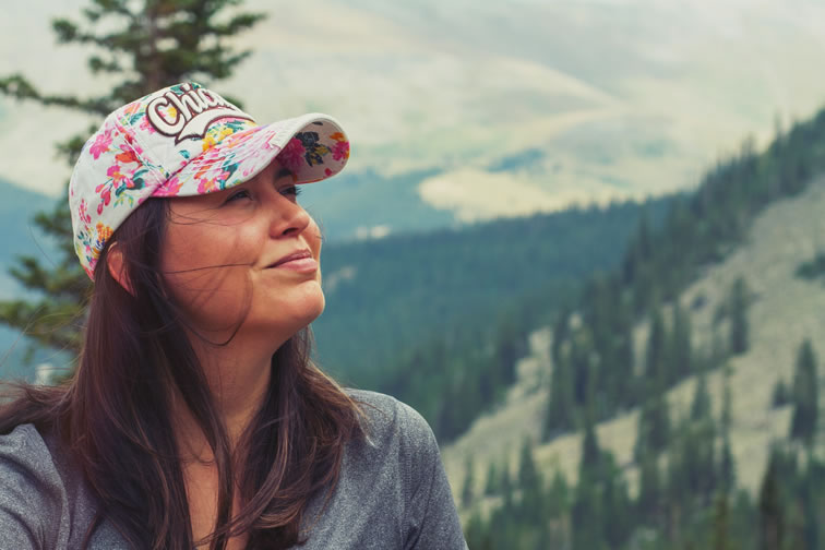 Woman hiking in the mountains and smiling feeling relaxed