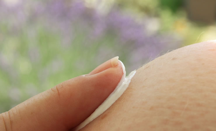 person using topical cream on skin 