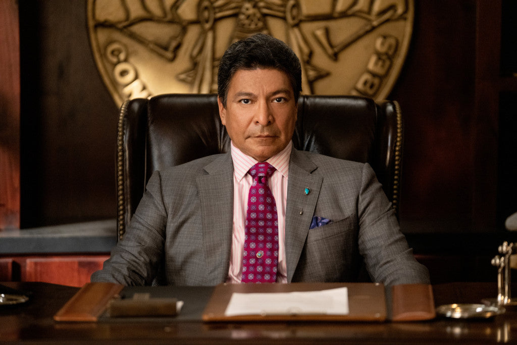 Man Sitting at a Desk Wearing a Suit