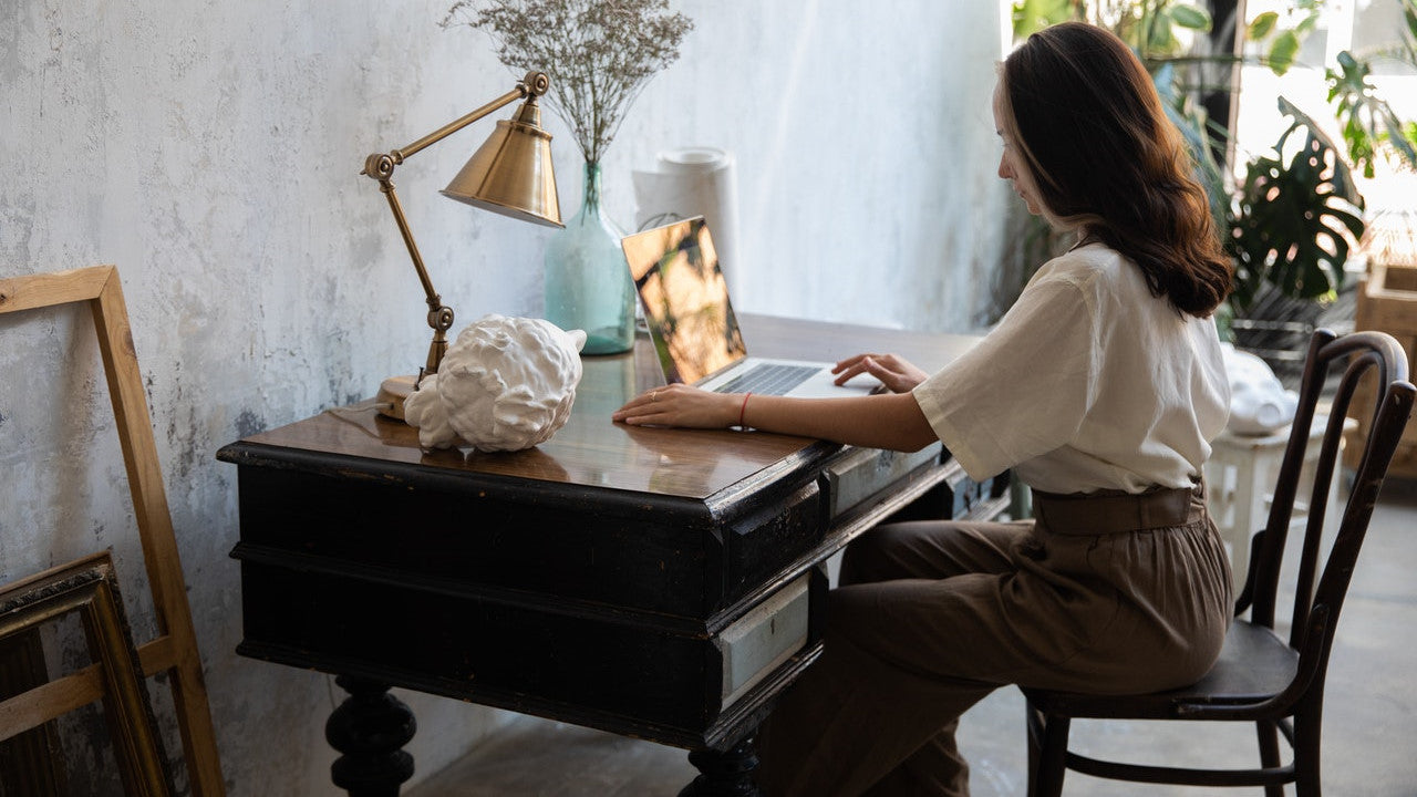 Woman working at an antique wooden desk