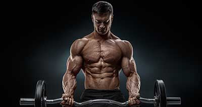 Muscular man curling weights