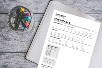 bead size chart and notebook on desk