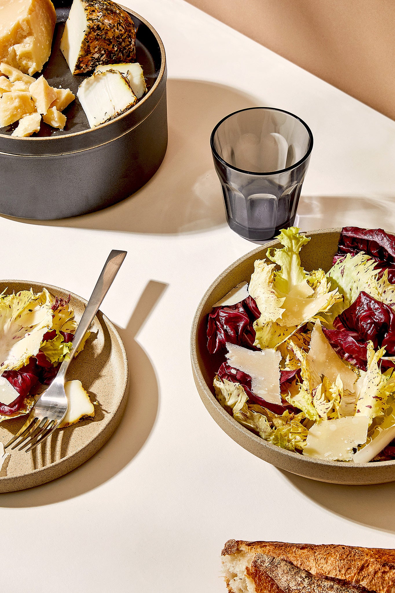 Salad, cheese, and bread in Hasami Porcelain plates and bowls on a table