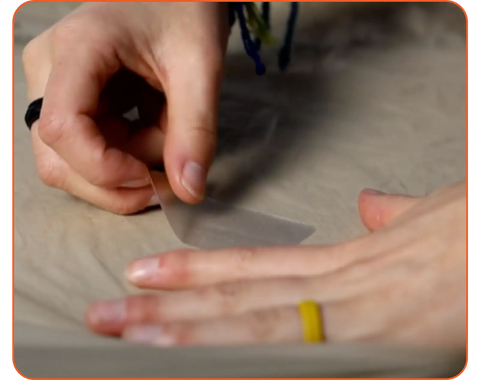 photo of woman's hands as she applies gear tape to repair outdoor gear