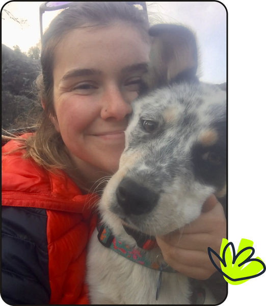 a pretty girl poses with her adorable blue heeler dog outdoors