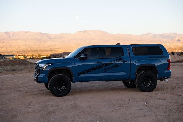theyotagarage 2022 toyota tundra cavalry blue with 6inch lift and 37" tires with method race wheels side shot