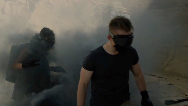 Man and woman wearing masks and goggles in smoky air