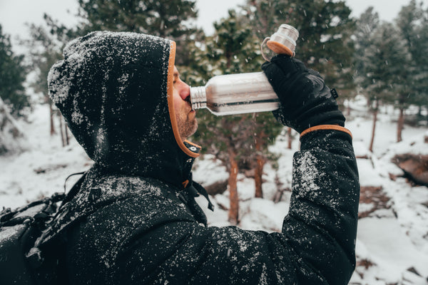 Man drinking water out of a stainless steel bottle