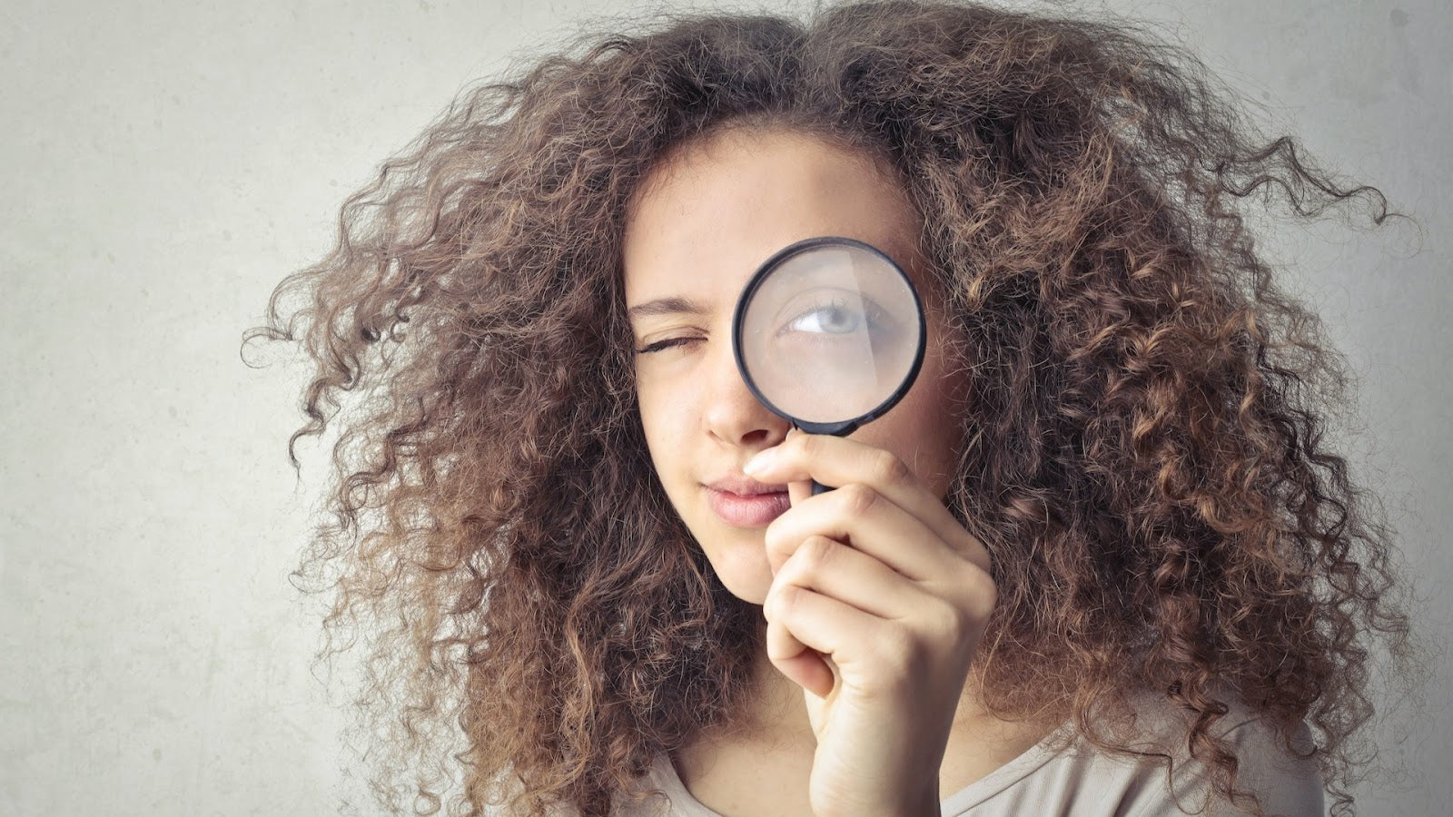 How A/B Testing Works -- A woman holding a magnifying glass in front of her left eye