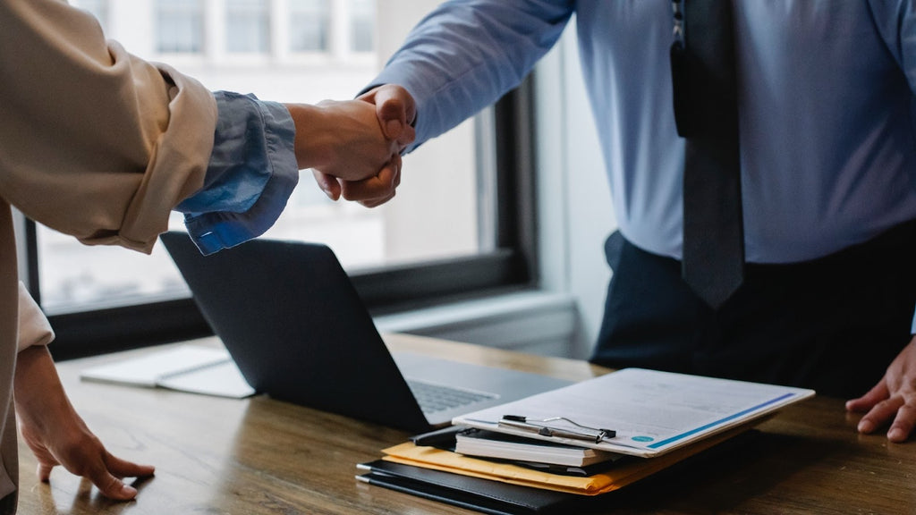 Man and woman shaking hands over the table