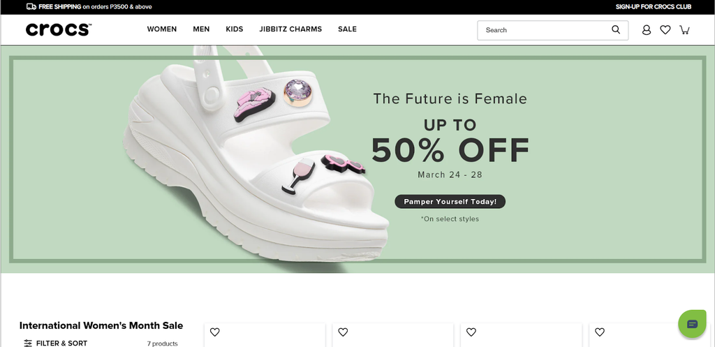 Homepage screenshot of Crocs' online store that shows a Croc sandal and announcing their 50% off for IWD