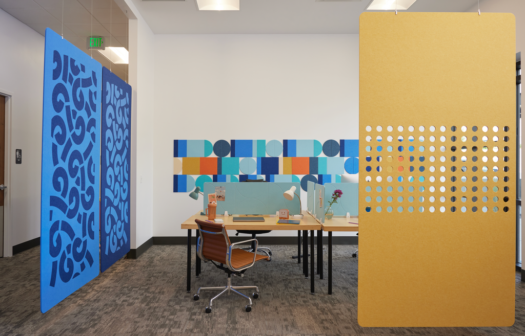 Desk dividers, hanging partitions, and noise control tiles in an office setting