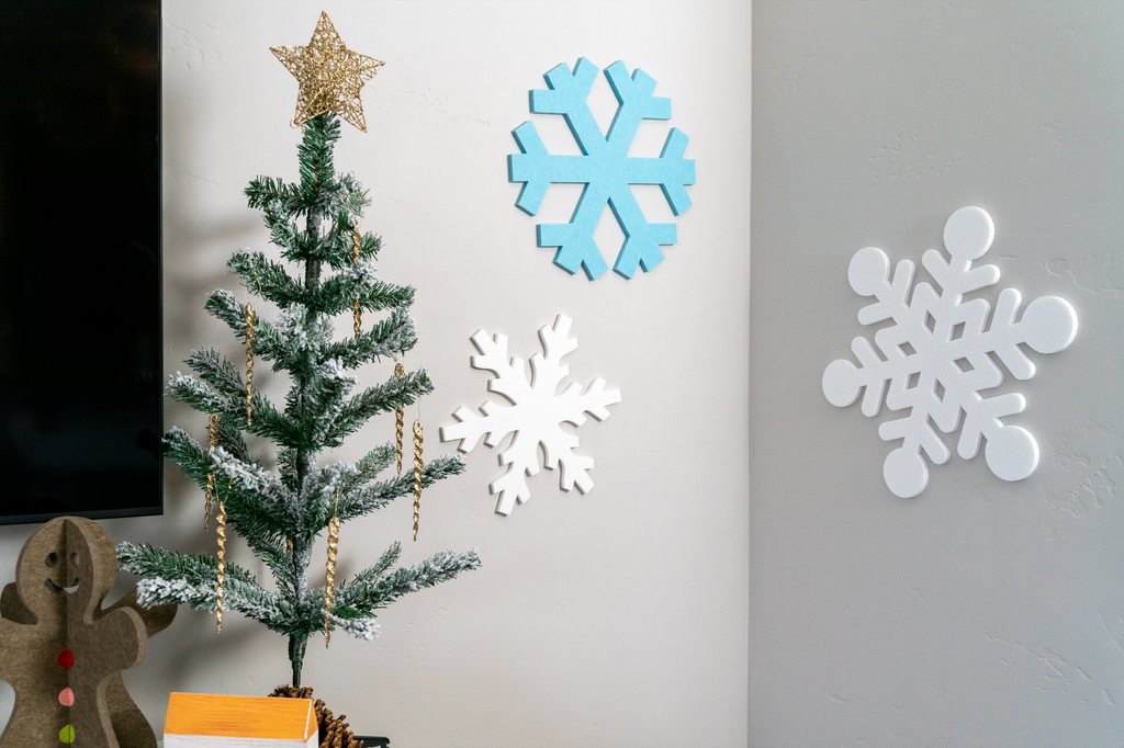 Felt Right tiles cut into 3 snowflake shapes which are adhered to the wall as a holiday art display.