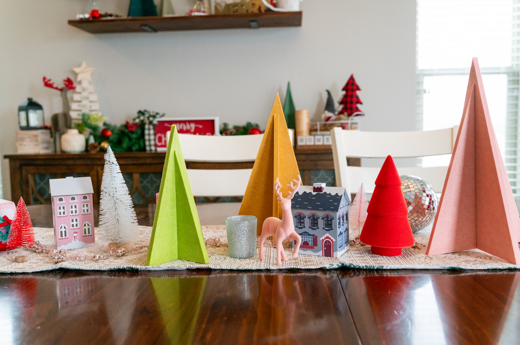 Felt Right Multicolor 4 Piece Tree pack displayed on a table with various winter decorations.