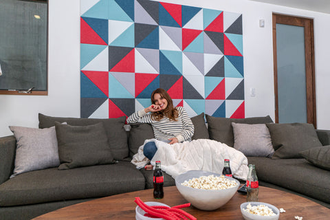 woman on couch in front of colorful mid century modern felt wall tiles
