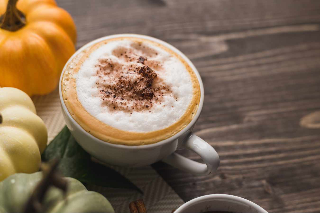 A cup of Pumpkin Spice Latte with milk foam on top.