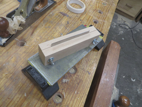 The vise, turned over and on a diamond stone on a wooden workbench