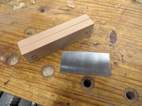 A finished scraper vise and a scraper on a wooden workbench