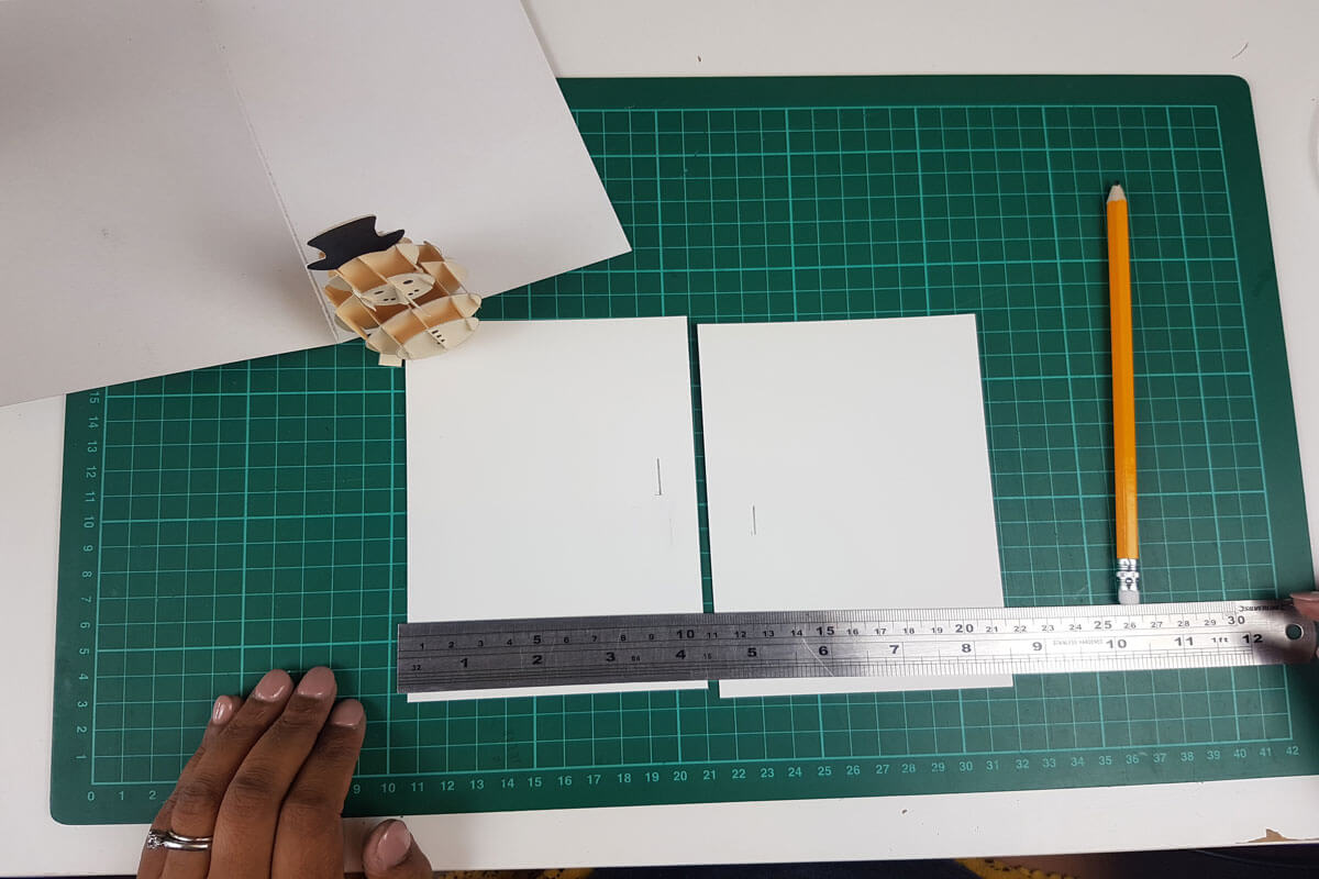 How To Make a 3D Christmas Pop Up Card - picture of cutting slits into the inner cover where you will slide in the pop up snowman