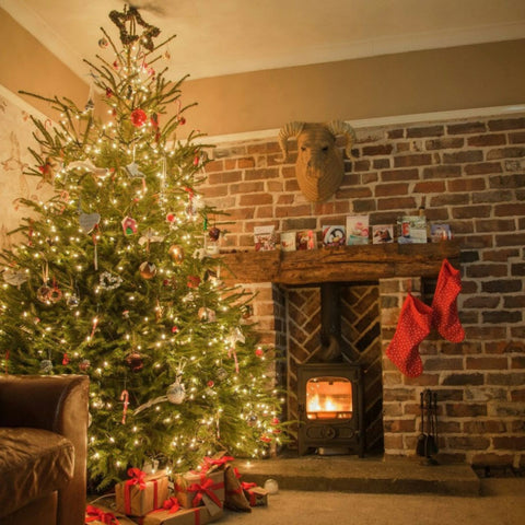 alt="not feeling christmassy, how to find your christmas spirit, cosy christmas tree with woodburner by Bramble & Fox UK hygge shop"