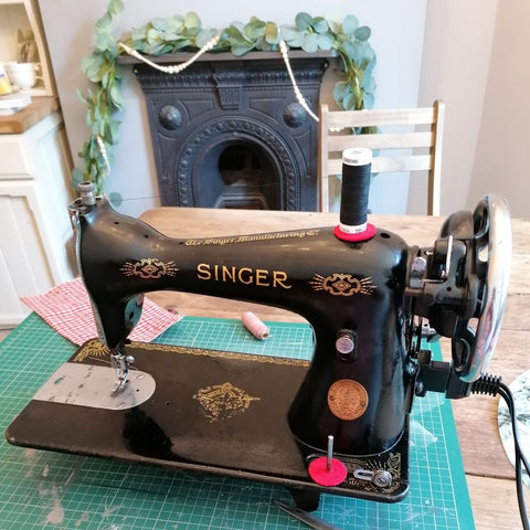 alt="learning how to use a vintage 1930s singer 14k sewing machine at my dining table. Victorian fireplace in background. Read Bramble and Fox hygge interiors blog"