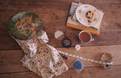 alt="sewing flat lay including vintage peek and frean cottage biscuit tin. Would make a perfect sewing tin. Available from Bramble and Fox uk cosy handmade and vintage homewares."