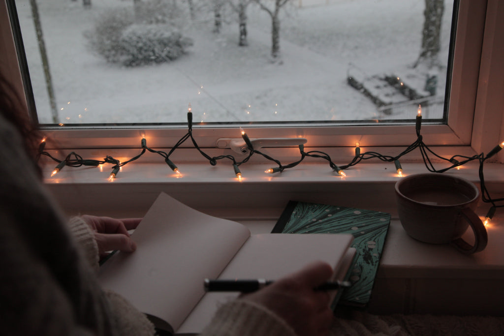 alt="opened journal with pen poised and snowscape"