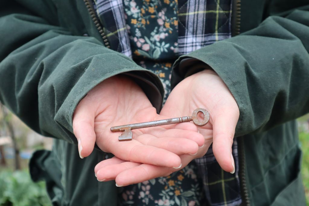 alt="A vintage key lay in a woman's open palms. Vintage key available from Bramble and Fox UK hygge shop."