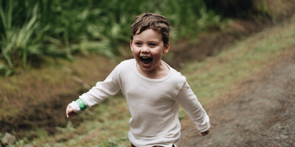 little boy running happy in woods
