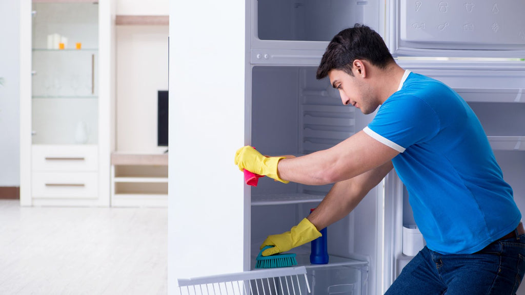 Man cleaning fridge drawers