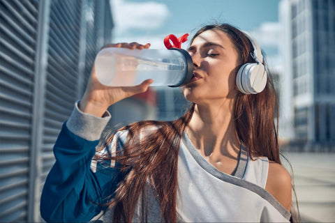 girl drinking water to stay hydrated when spending time outside