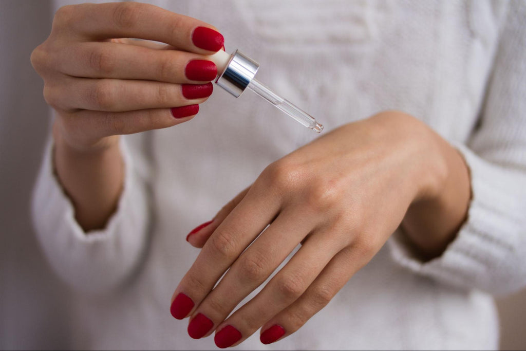 woman applying serum  on her hand 