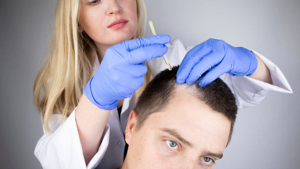 man receiving medical treatment from a doctor for hair loss
