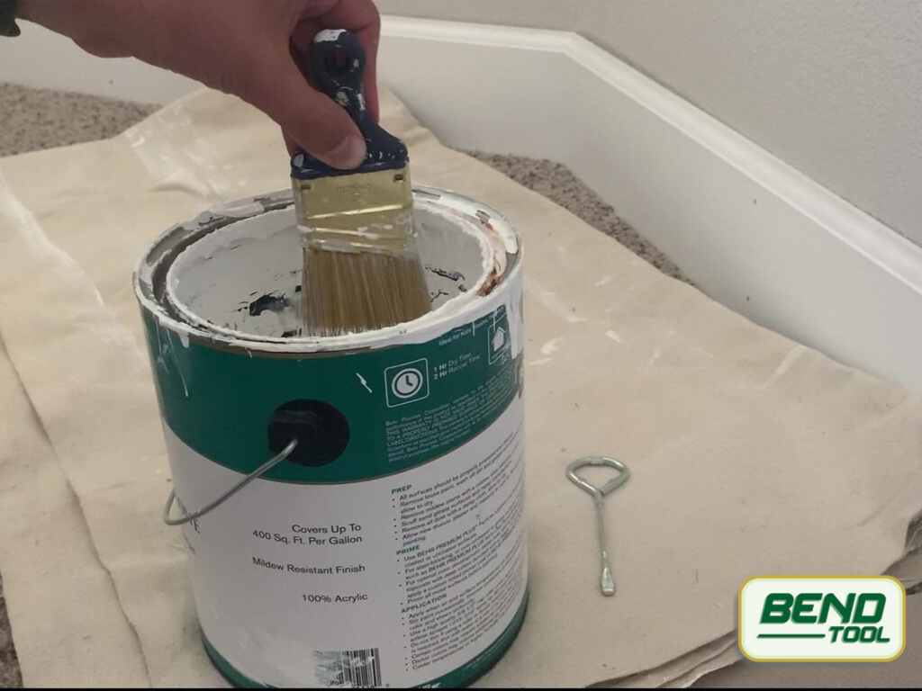 How to paint baseboards with carpet - tapping brush gently against paint can before applying