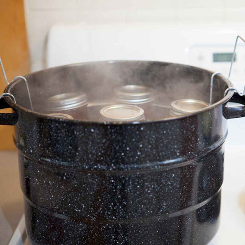 Boiling homemade fruit jam into jar