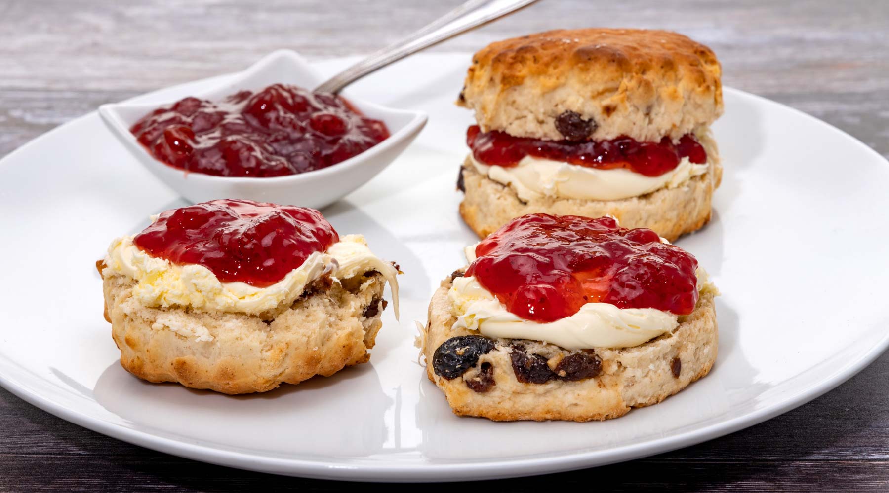 Scones covered with cream and raspberry jam