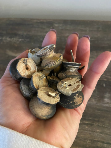 woman's hand holding a bunch of old wooden knobs