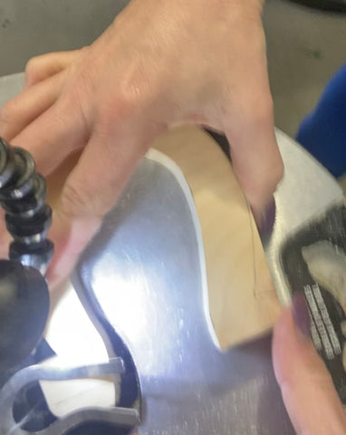 close up of a person cutting a piece of wood using a scroll saw