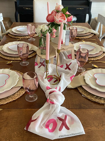 table decorated with pink and white dinnerware and flowers