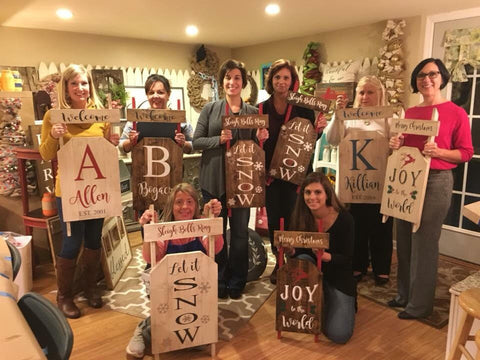 several people holding wooden sleds at a workshop event