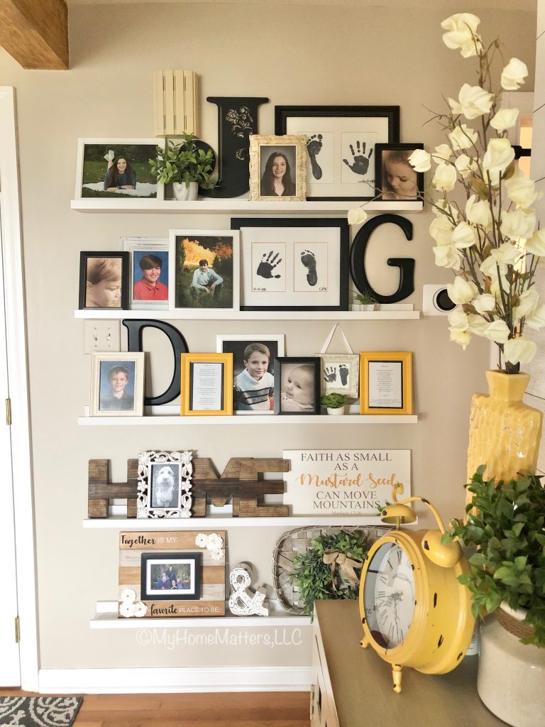 a gallery wall of family photos in an entry hall