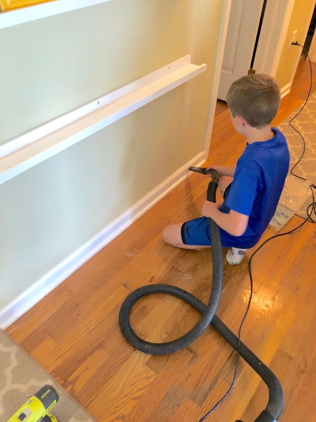 child vacuuming up dust on a floor