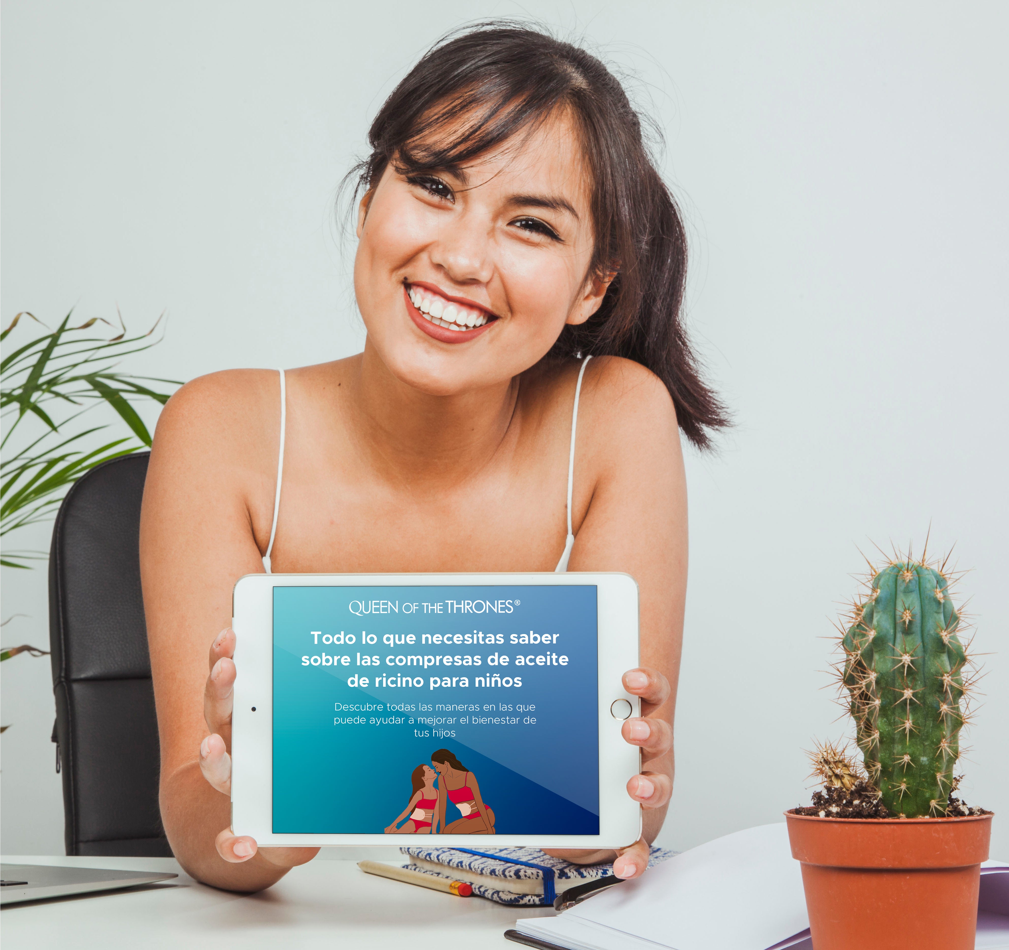 Woman smiling with an Ipad displaying Can Kids wear Castor Oil Packs?  Yes!