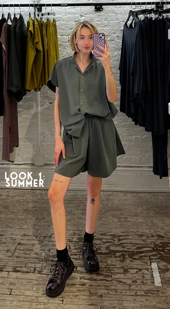 Leah wearing the matching Triangle Shirt and Gathered Short in Army Green with chunky black shoes.