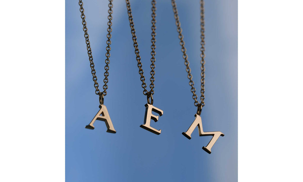 EC One signature letter necklaces in recycled gold