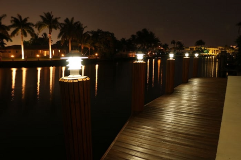 Beautiful dock all lit up by LED dock lighting at night on a marina with palm trees nearby