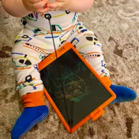 a toddler with the colorful lcd writing and drawing tablet