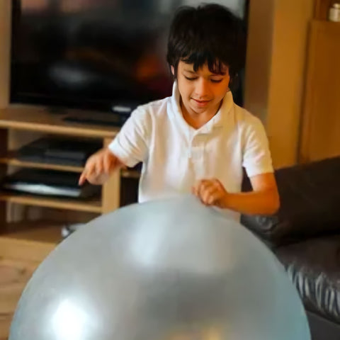 a boy playing with a giant jelly balloon ball