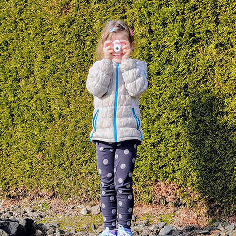 a child taking pictures using the littlelens camera outdoors