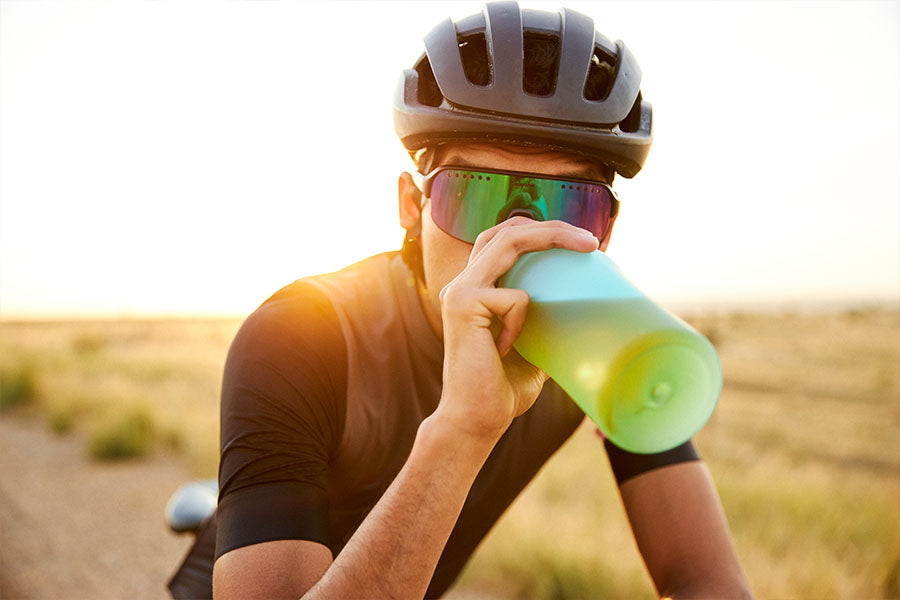 a man is drinking tea from a water bottle while on his bike